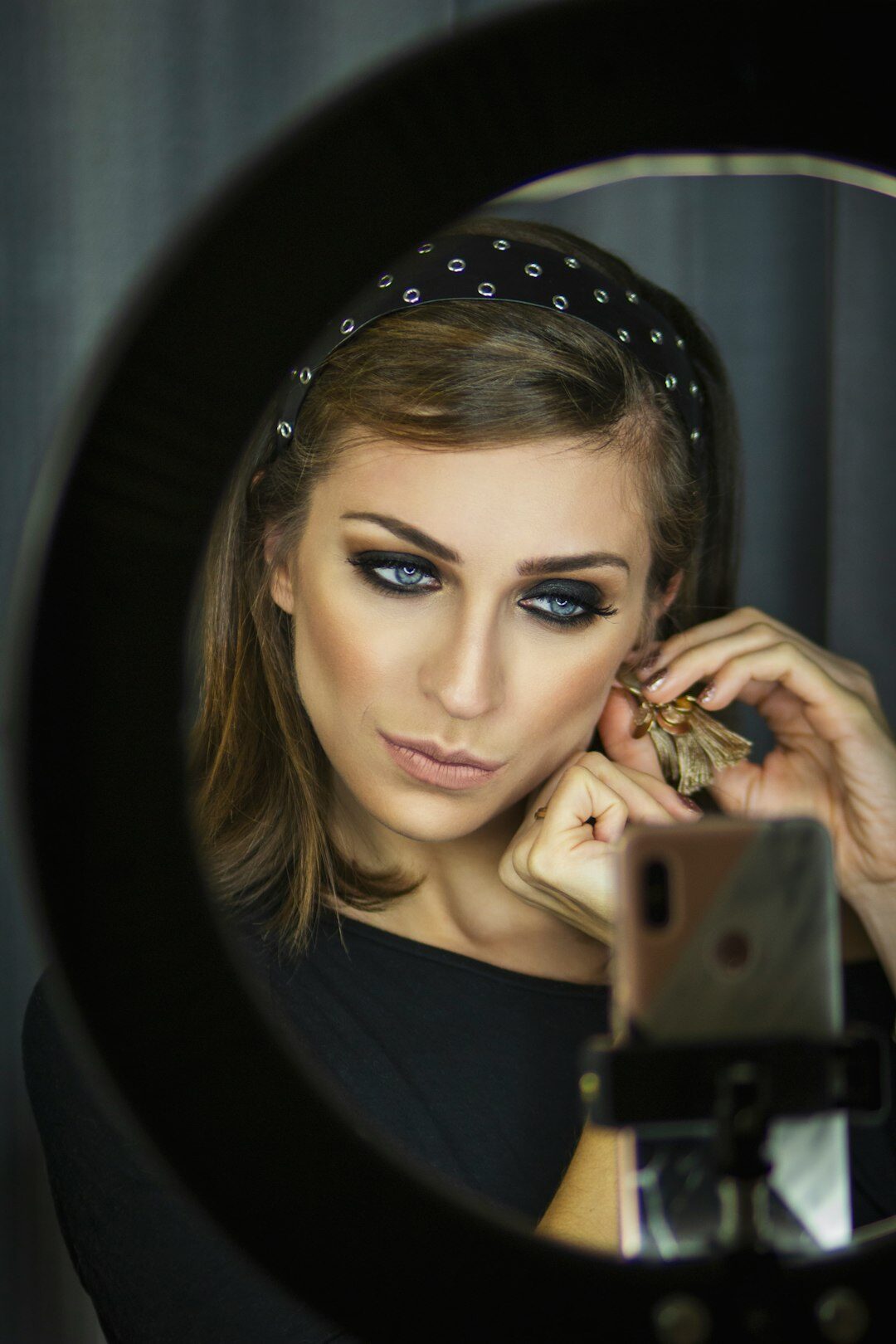 Young woman recording content with a smartphone and ring light